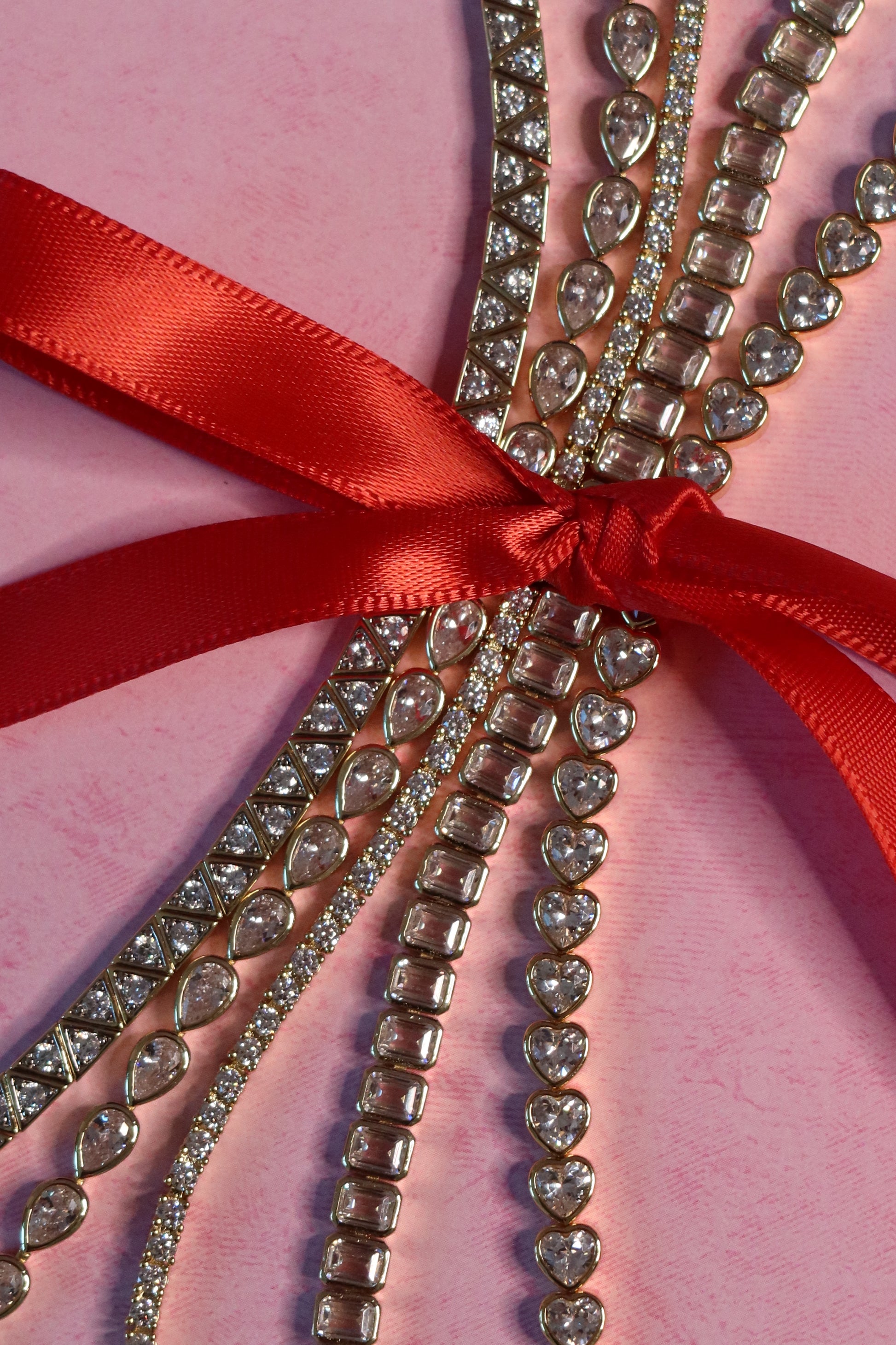 Decorative ribbon with heart-shaped embellishments on a pink background