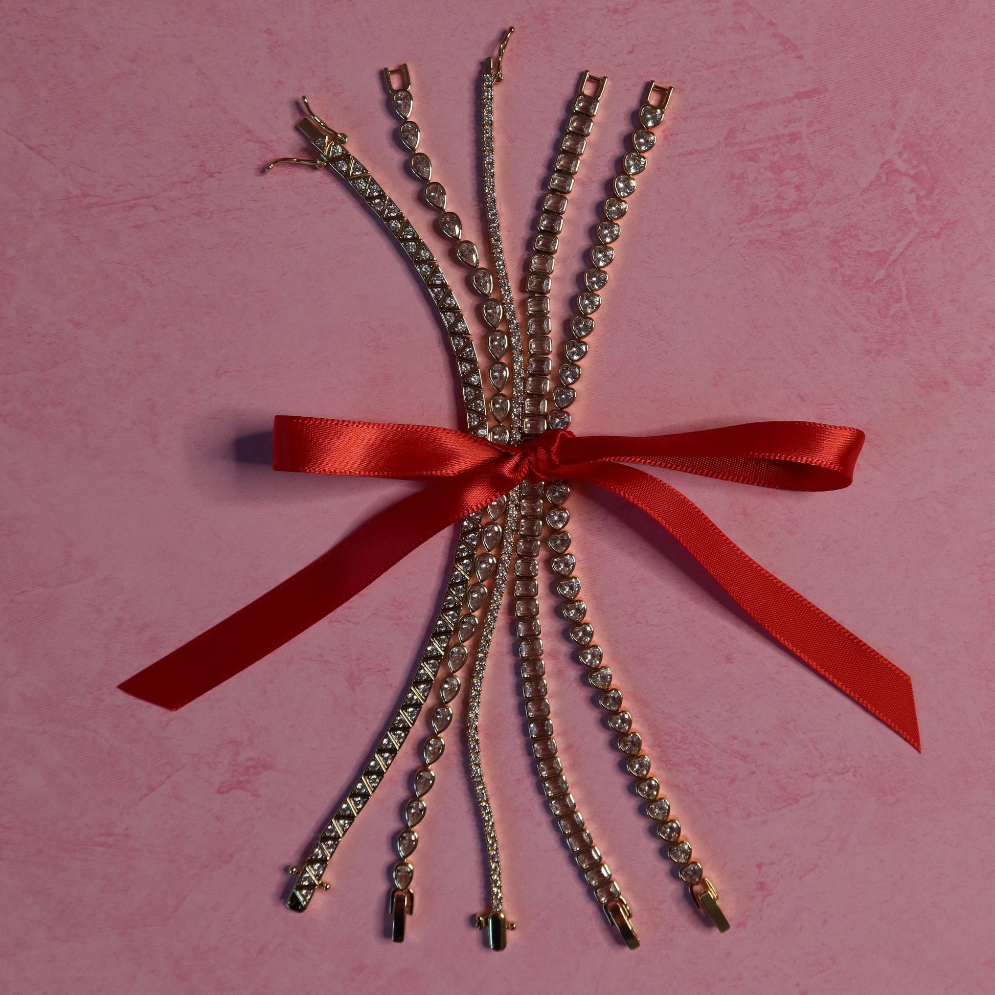 Bouquet of silver chains with a red ribbon on a pink background